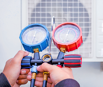 HVAC technician using pressure gauges