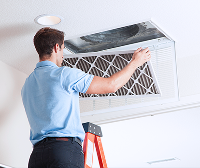 Technician installing HVAC air filter